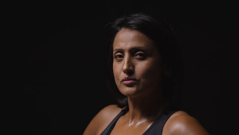 Studio-Portrait-Of-Mature-Woman-Wearing-Gym-Fitness-Clothing-Sweating-After-Exercise